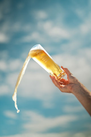 A drink being poured against a bright blue sky